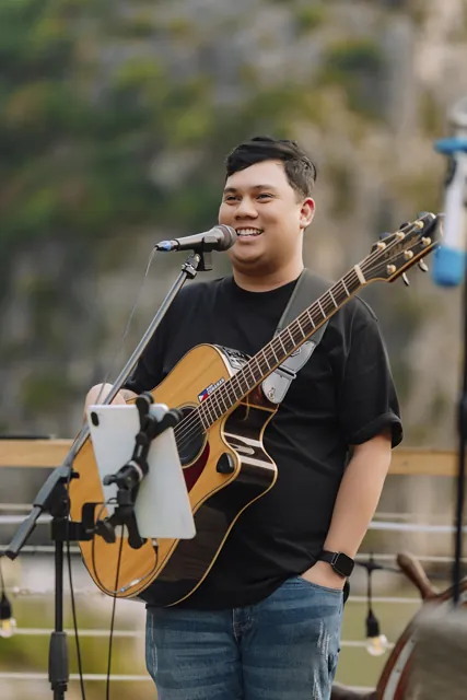 Ralph smiling and singing with his guitar